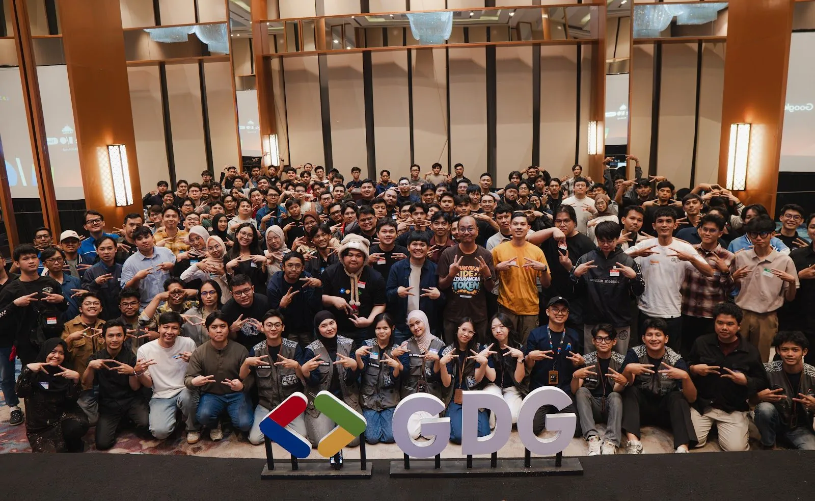 DevFest Bandung attendees posing together behind the GDG sign