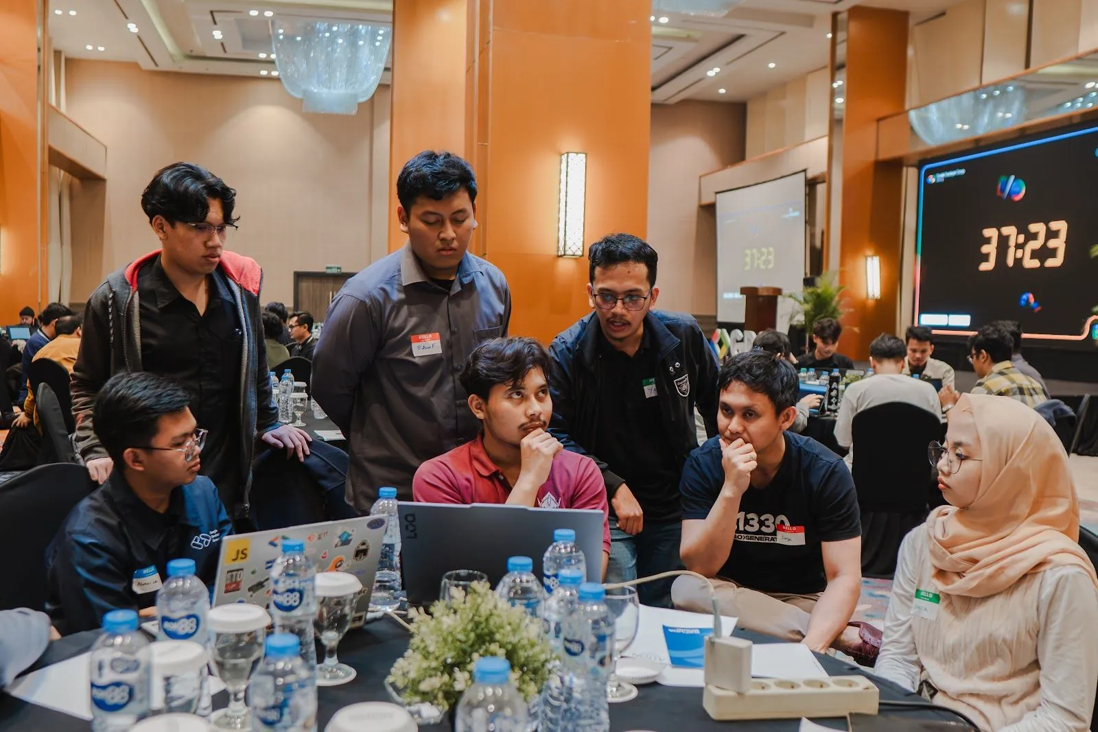 A team gathered around a laptop during the hackathon